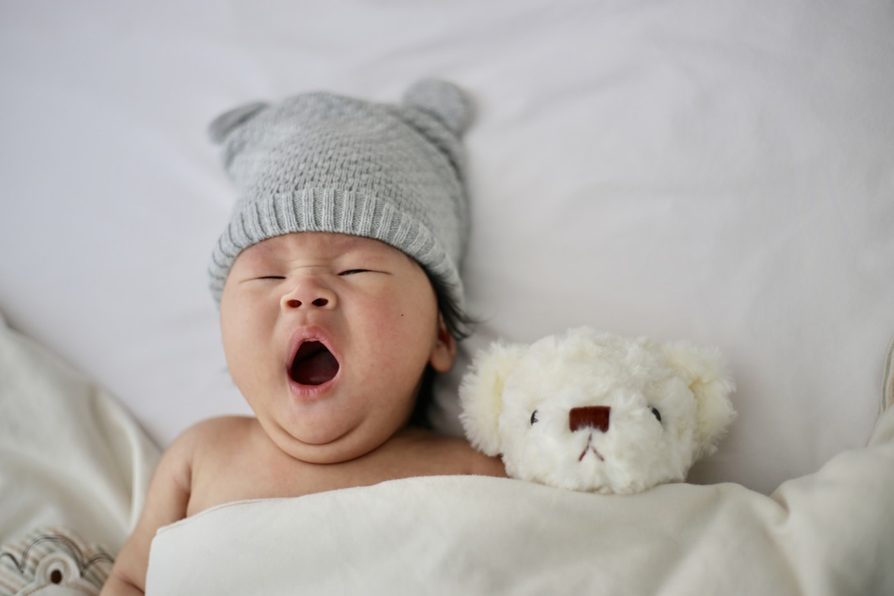 Bébé endormi paisiblement avec un petit ours en peluche